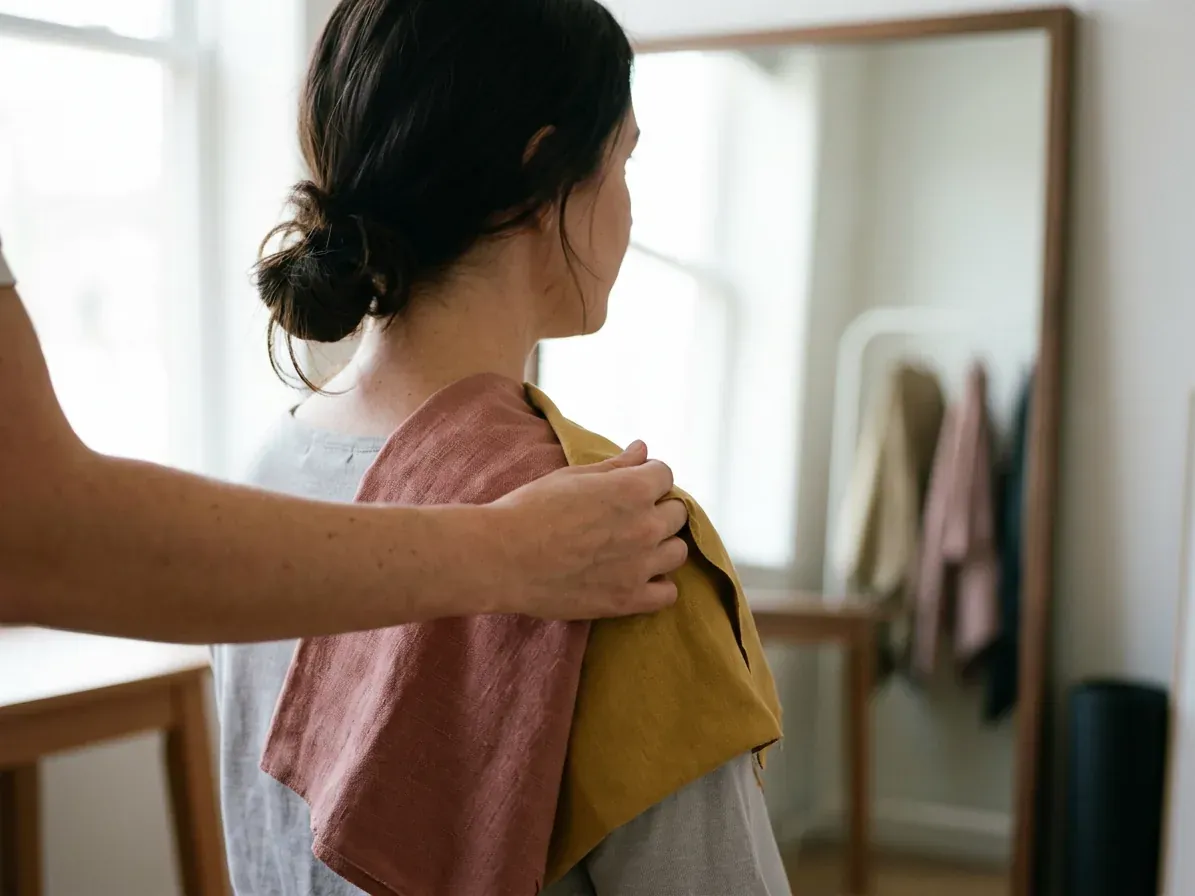 What colors look good on me: two fabric drapes held at the shoulder in daylight